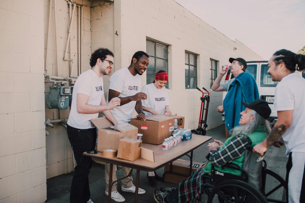 A group of volunteers engaging in a community service activity outdoors, providing aid and support.